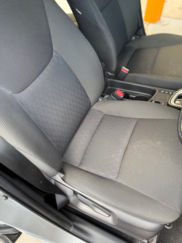 Gray fabric car seat with textured pattern and black trim in a vehicle interior