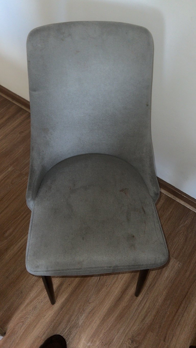 Gray upholstered dining chair before cleaning